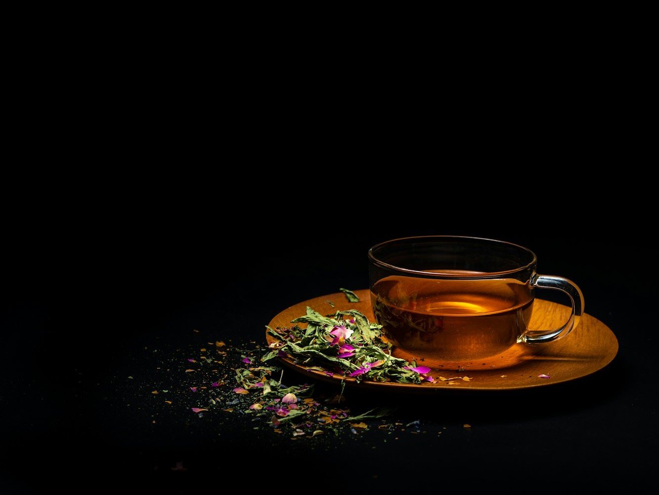 Une tasse de tisane et des fleurs séchées, servie après le soin