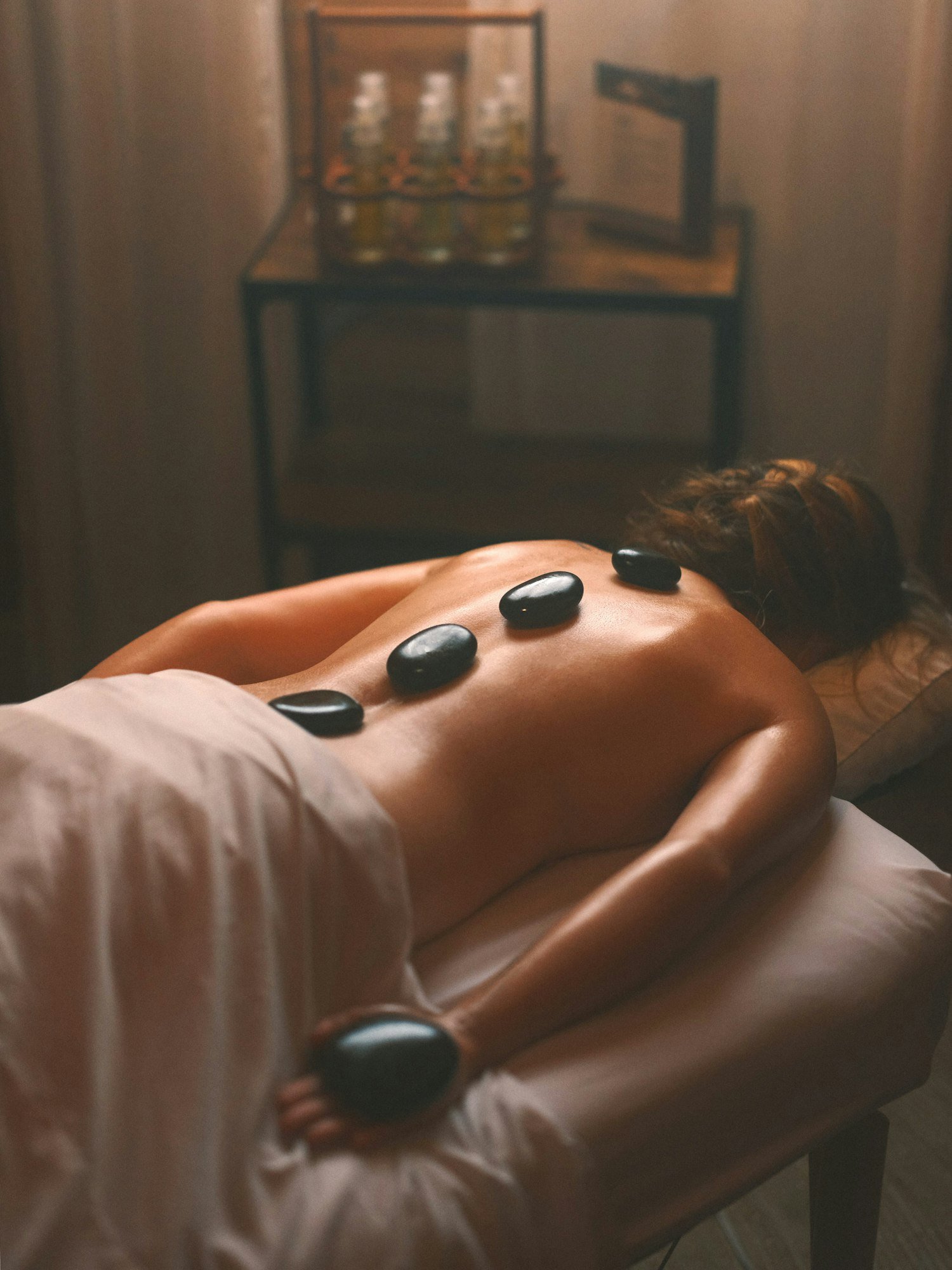 Massage aux pierres chaudes : des galets de basalte posés le long du dos